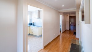 A hallway leading to a kitchen with a modern stove, wooden flooring, and a door leading to a bedroom. - Cubo's Central Bright Marbella Apartment / urban / free wifi (Marbella)