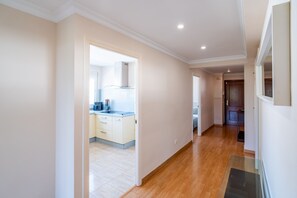 A hallway leading to a kitchen with a modern stove, wooden flooring, and a door leading to a bedroom. - Cubo's Central Bright Marbella Apartment / urban / free wifi (Marbella)