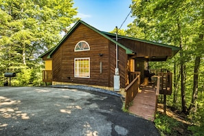 A wooden cabin with a covered porch, a mailbox, and a gravel driveway. - Couples Winter Haven | VIEW, Barrel Sauna, Hot Tub (Sevierville)