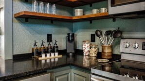 A kitchen with wooden shelves, a coffee maker, and various kitchen utensils. - NEW Couples! VIEW, Barrel Sauna, Hot Tub, Fire Pit (Sevierville)