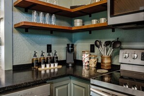A kitchen with wooden shelves, a coffee maker, and various kitchen utensils. - NEW Couples! VIEW, Barrel Sauna, Hot Tub, Fire Pit (Sevierville)