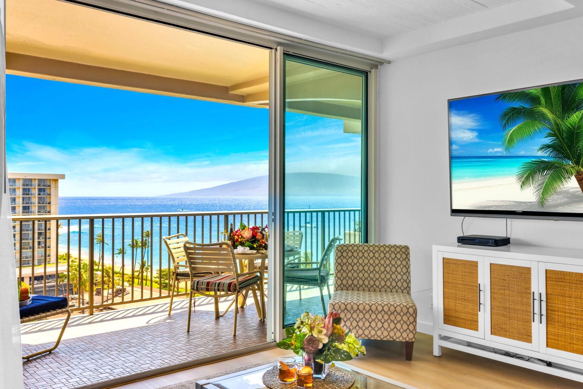 Un balcon avec vue sur l’océan, une télévision et un coin salon avec une table.