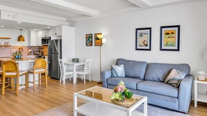 Una sala de estar moderna con sofá, mesa de centro y comedor.