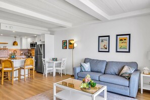 A modern living room with a sofa, coffee table, and dining area. - Whaler | Ocean View 3 BR Sleeps 12 | Car Incl. w/ 6+ Nights | ML-4229 by KBM (Lahaina)