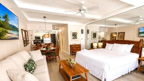 Una habitación de hotel con cama, sofá, mesa de comedor y zona de cocina.