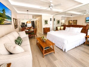 A hotel room with a bed, a sofa, a dining table, and a kitchen area. - Whaler | Ocean View 3 BR Sleeps 12 | Car Incl. w/ 6+ Nights | ML-4229 by KBM (Lahaina)