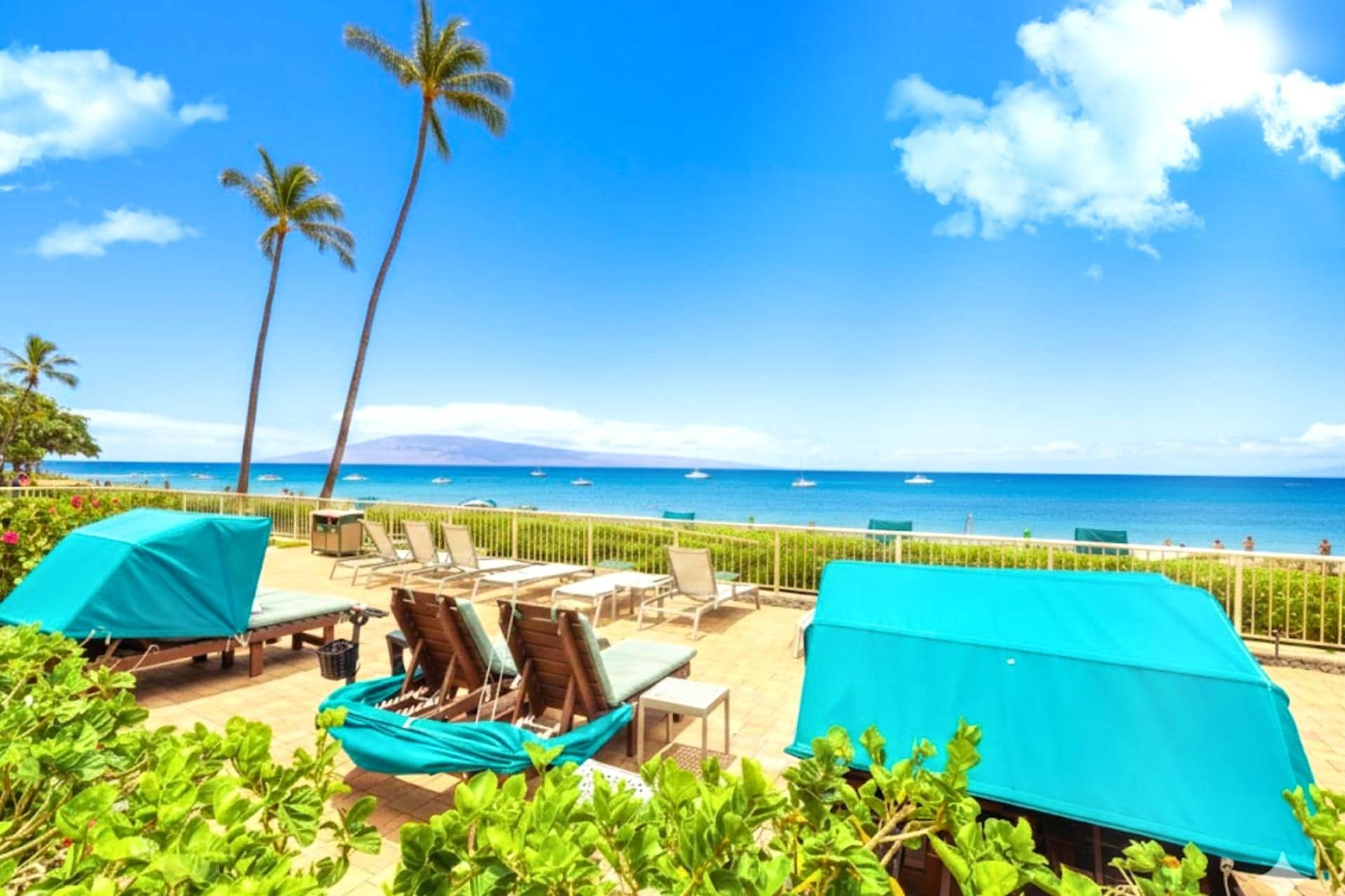 Un espace de détente aménagé au bord de la plage, avec des chaises longues et une vue sur l’océan.