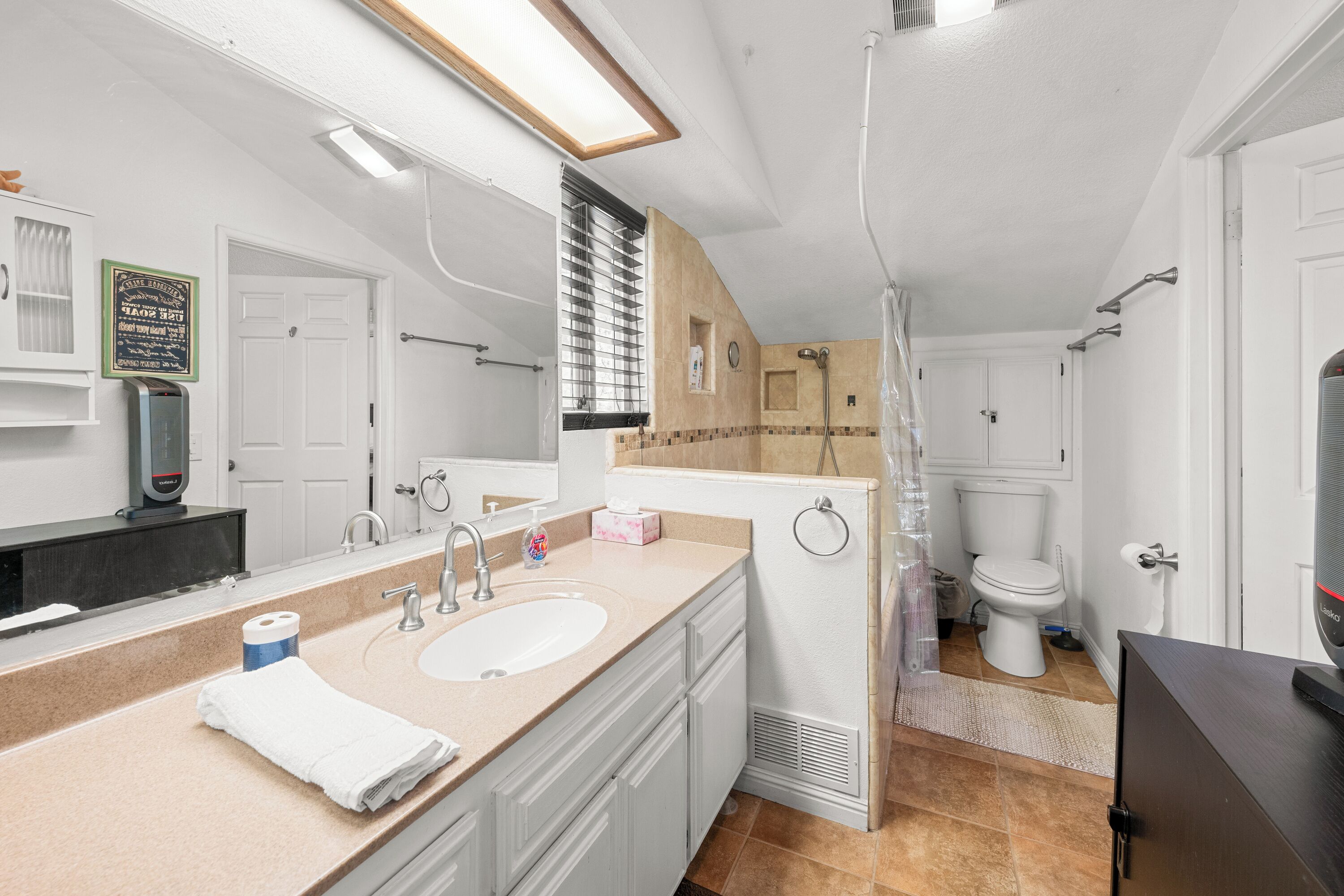 Un baño moderno con lavamanos doble, ducha e inodoro.
