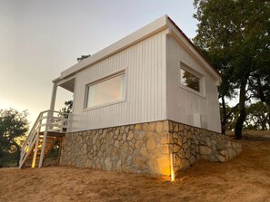Una casa moderna amb fonaments de pedra i façana blanca.