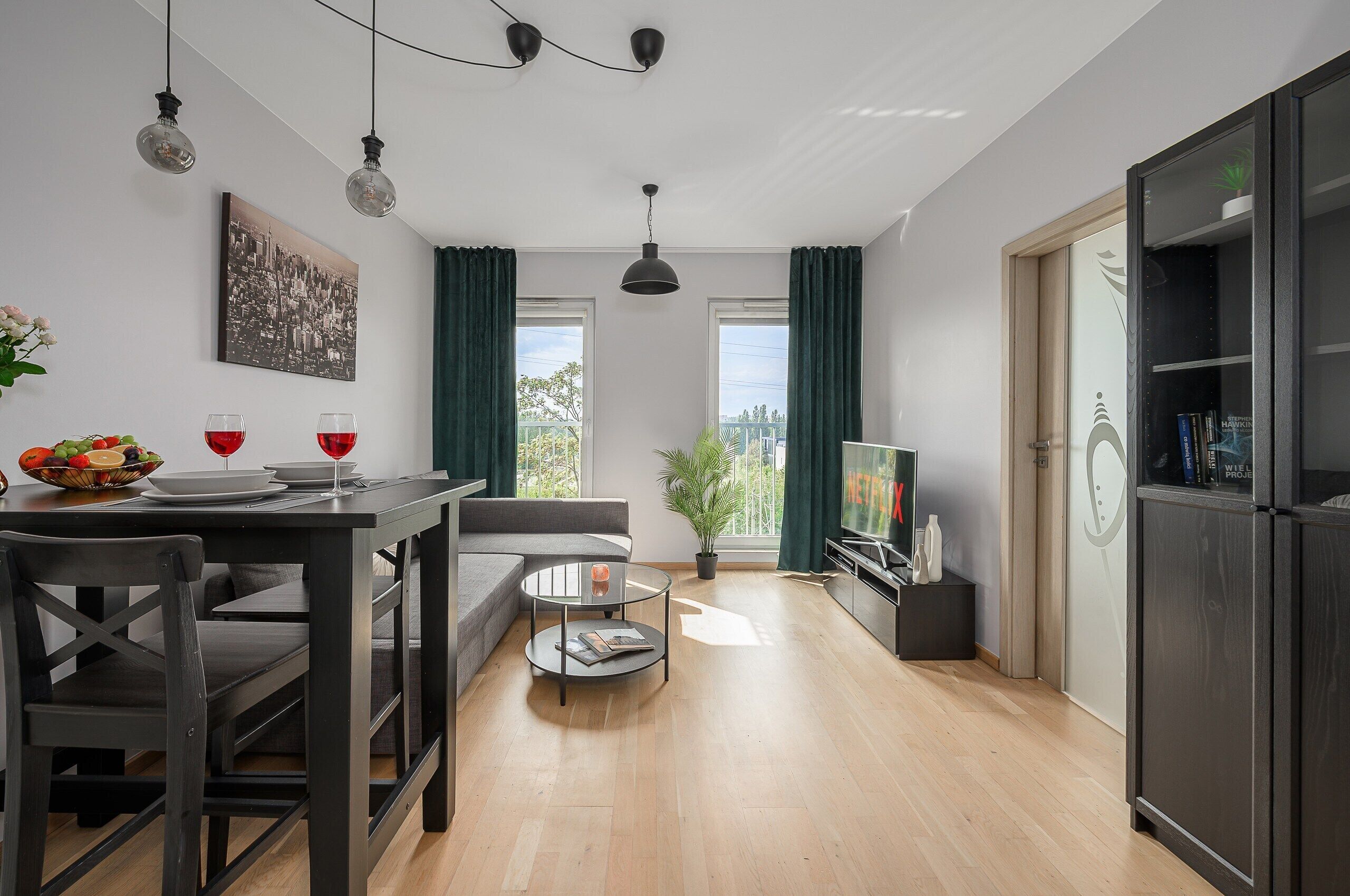 Un salon moderne comprenant un coin repas, un canapé, une table basse et un téléviseur.