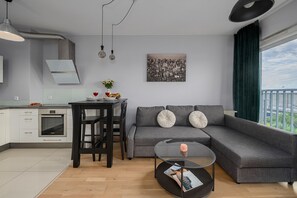 A modern living space with a kitchen, dining area, and a large window with a city view. - Lumina 2-room Apart with Balkony & Metro (Warszawa)