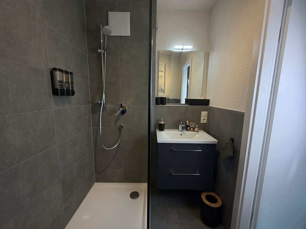 Ein modernes Badezimmer mit Dusche, Waschbecken und Toilette.