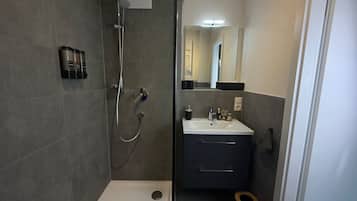 Ein modernes Badezimmer mit Dusche, Waschbecken und Toilette.