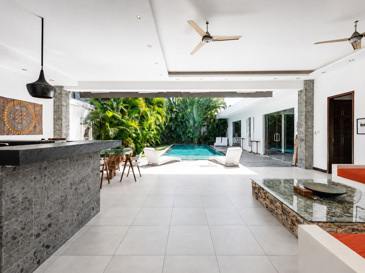 A modern interior with a pool, a dining area, and a kitchen.