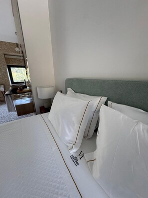 Et hotelværelse med en seng, et natbord, en lampe og et vindue med udsigt.