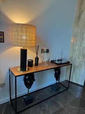 Et moderne interiør med et træbord, en vævet lampe og dekorative genstande.