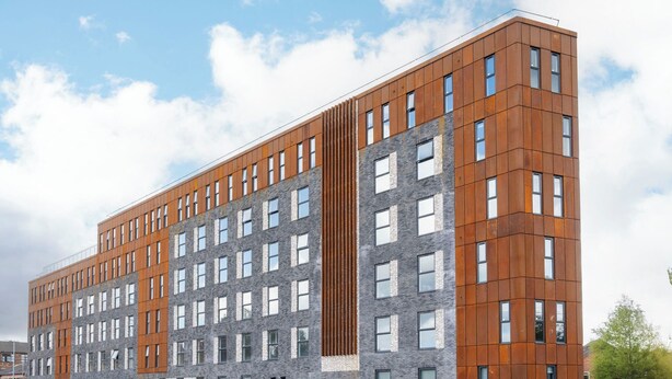 A multi-story building with a modern architectural design, featuring a combination of brick and wooden panel facades, and a series of windows arranged in a grid pattern. - Student Only Icon House (Stoke-on-Trent)