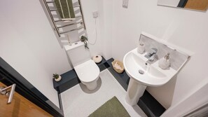 Ein kleines Badezimmer mit Toilette, Waschbecken und Handtuchhalter.