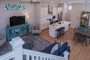 Une cuisine moderne avec des meubles blancs, un îlot central et un coin repas comprenant une table et des chaises.