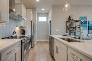A modern kitchen with stainless steel appliances, a dishwasher, and a double sink. - Your Nashville home base-comfort close to downtown (Nashville)