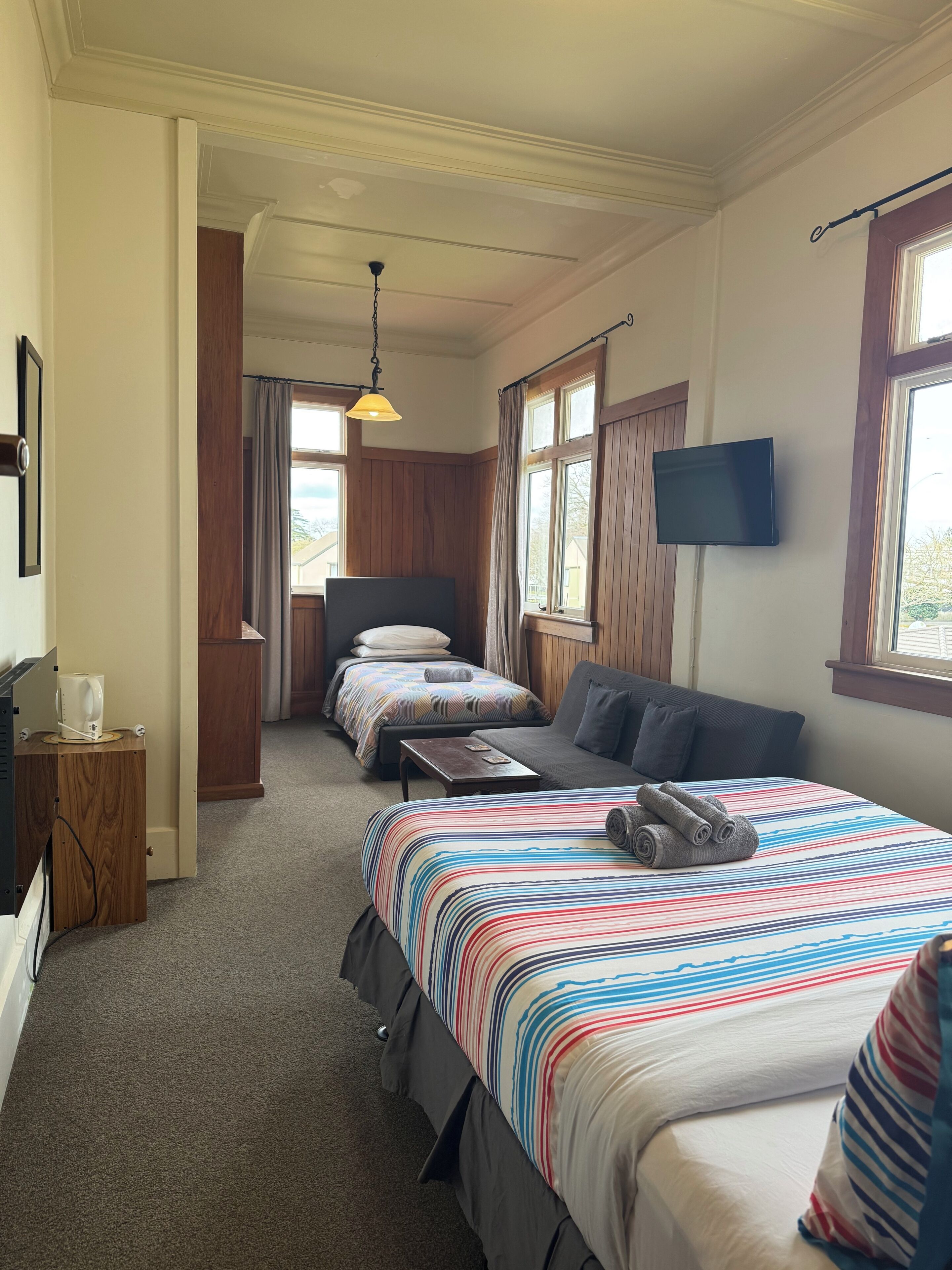 Una habitación de hotel con una cama grande, un sofá, un escritorio y un televisor.