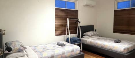 Una habitación con dos camas individuales, una mesita y una silla.