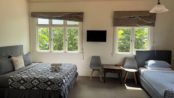 Un dormitorio con dos camas, un escritorio y una televisión.