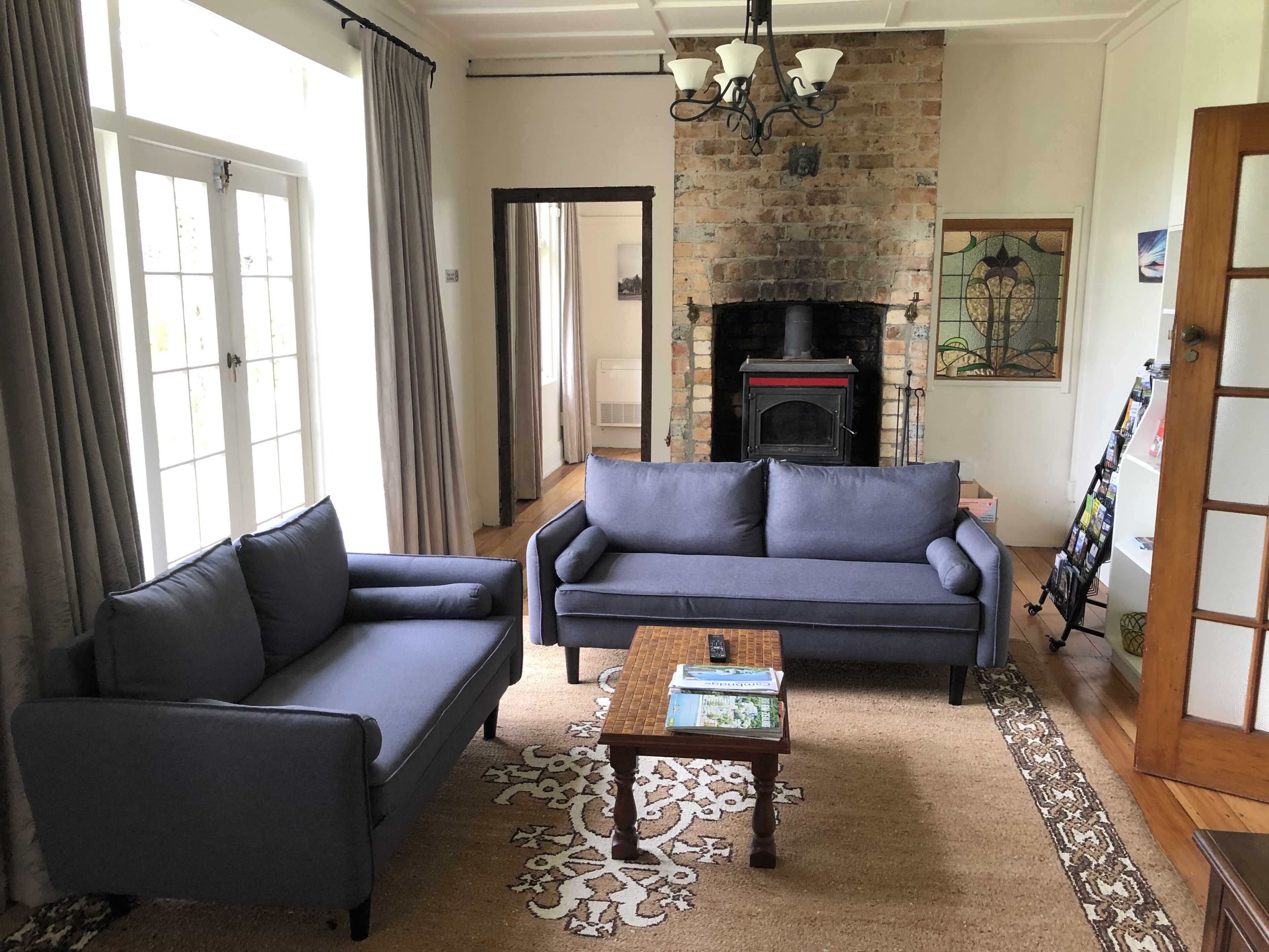 A living room with a fireplace, two sofas, a coffee table, and a patterned rug.