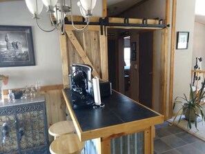 A kitchen with a wooden counter, a coffee machine, and a hanging light fixture. - Desert Serenity – Private 3BR/2BA Retreat Near Moab & National Parks (Moab)