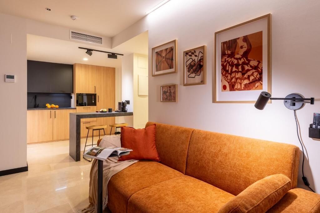 Un salón moderno con un sofá, una mesa de centro y una cocina al fondo.