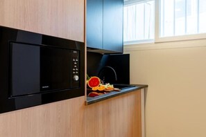 A kitchen with a built-in microwave and a modern stove. - VORS&Co Jerez (Jerez de la Frontera)