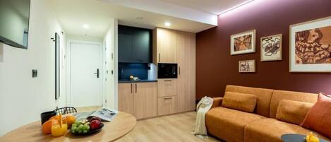 Un espace de vie moderne comprenant un coin repas, une kitchenette et un canapé.