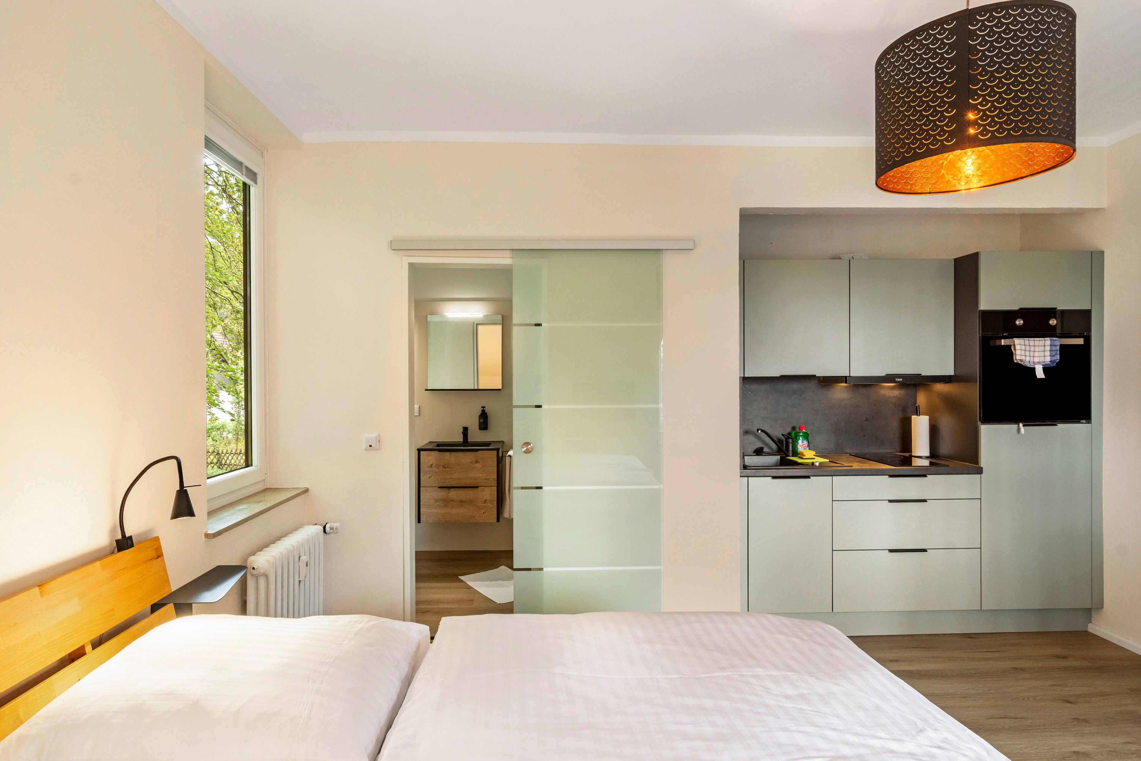 Une chambre à coucher moderne avec un lit, une fenêtre et une vue sur l’extérieur.