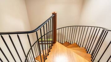 A wooden staircase with black metal railings leading to an upper floor.