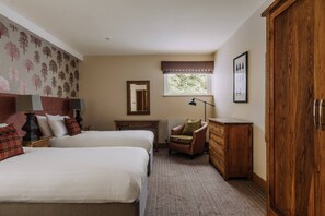 Une chambre avec deux lits, une commode, une chaise, une fenêtre et un miroir.