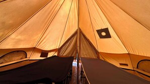 A tent with a central pole and multiple sleeping areas.