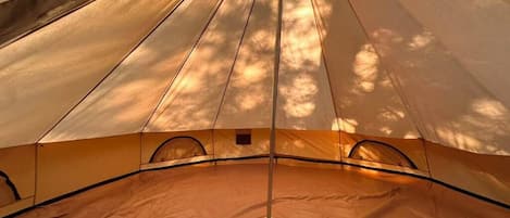 A tent with a central pole, a peaked roof, and a ground tarp.