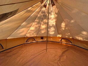 A tent with a central pole, a peaked roof, and a ground tarp.