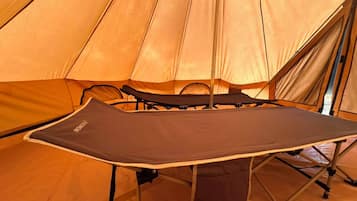 A tent interior with a foldable table and chairs.