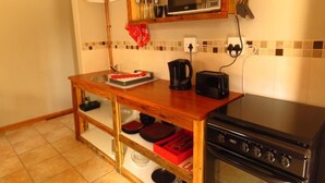 Cocina compacta con microondas, tostadora y estufa.