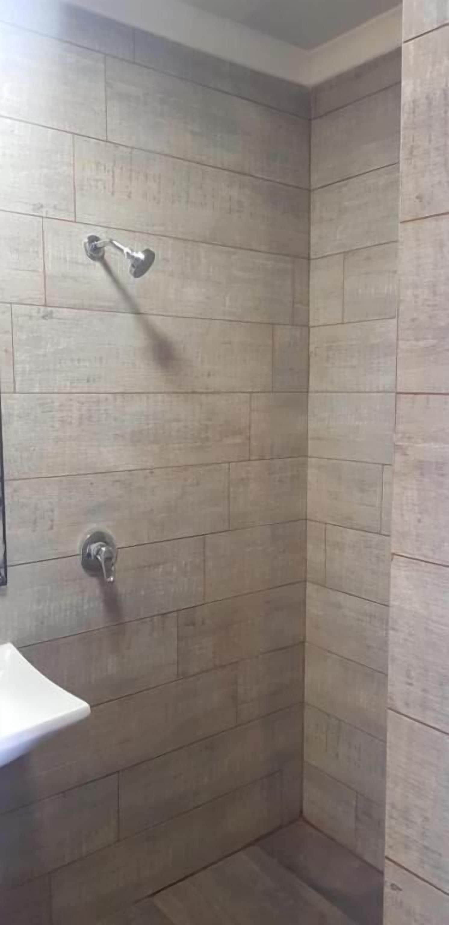 Ducha con cabezal de ducha de mano y grifo empotrado.