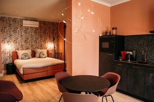 Un dormitorio con cama, mesitas de noche, una mesa redonda de comedor y sillas.