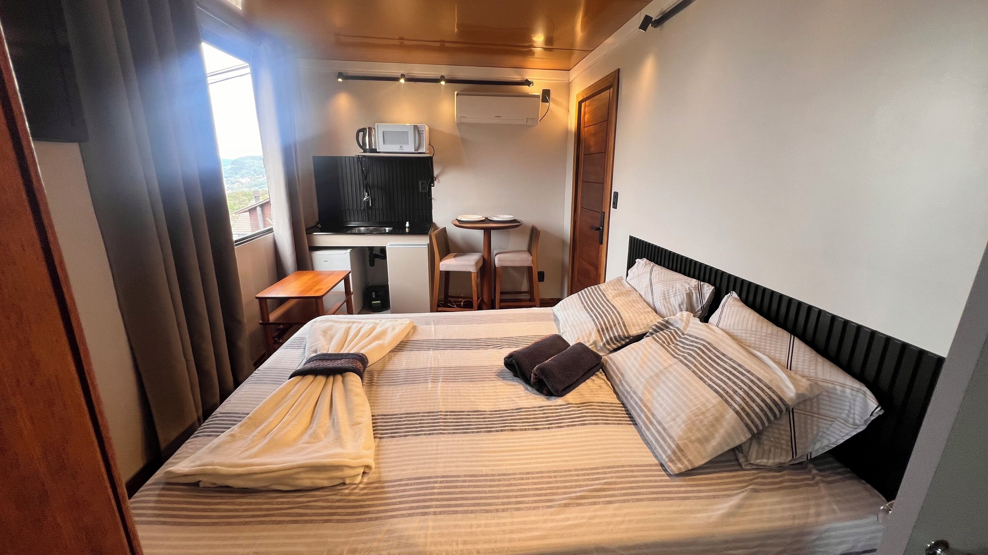 Une chambre d’hôtel équipée d’un lit, d’un bureau, d’une chaise, d’un four à micro-ondes et d’un appareil de climatisation.