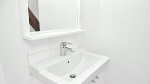 Chuveiro, secador de cabelo, toalhas de banho, papel higiênico