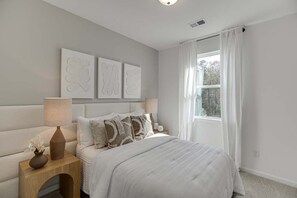 A bedroom with a bed, bedside tables, and artwork on the wall. - Tranquil 3-bedroom townhome with AC in vibrant Atlanta (Atlanta)