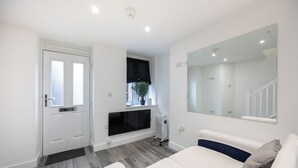 A bedroom with a bed, a large mirror, a radiator, and a door with windows.