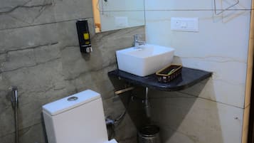 Un baño con inodoro, lavamanos, espejo y ducha.