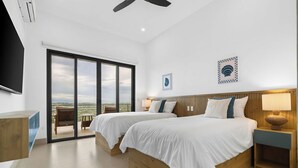 Een moderne hotelkamer met twee bedden, een balkon en een groot raam.