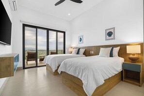 Ein modernes Hotelzimmer mit zwei Betten, einem Balkon und einem großen Fenster.