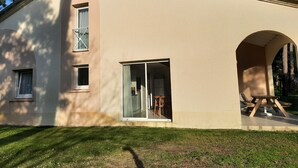 A two-story building with a beige exterior, large windows, and an arched doorway. - Residence with a pool next to the Moliets Golf Course; Duplex apartment for 8–9 people, 10 minutes from the ocean (Moliets-et-Maa)